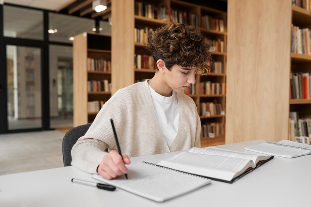 Giovane studente che impara in biblioteca