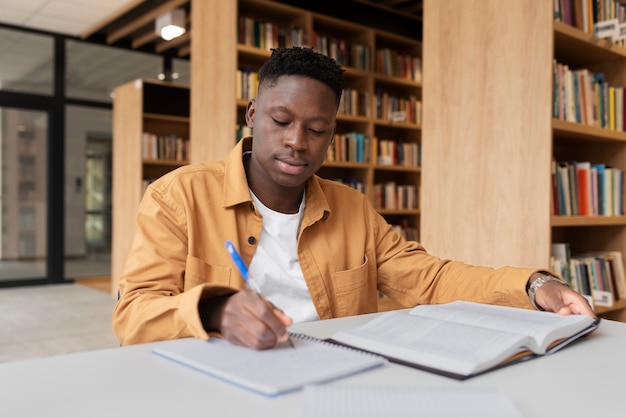 Giovane studente che impara in biblioteca