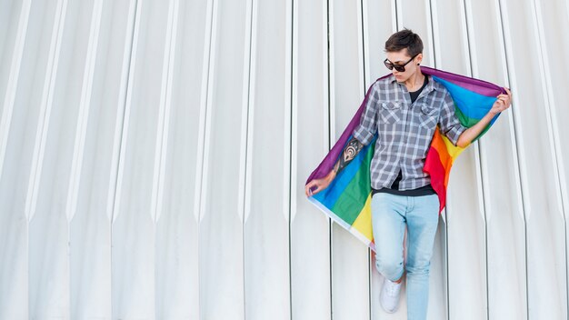 Giovane transgender che tiene la bandiera LGBT