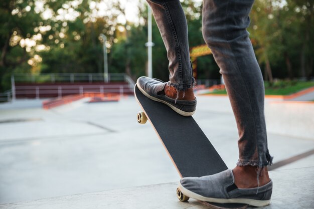 Giovane uomo africano che fa skateboard