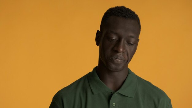 Giovane uomo afroamericano che sembra scontento sulla fotocamera isolata su sfondo giallo