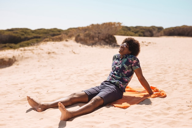 Giovane uomo afroamericano sorridente che gode del sole