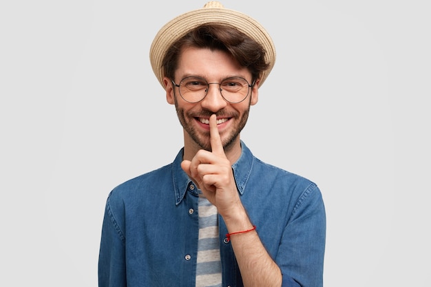 Giovane uomo barbuto con occhiali rotondi e camicia di jeans