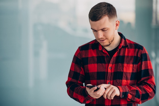 Giovane uomo bello che per mezzo del telefono