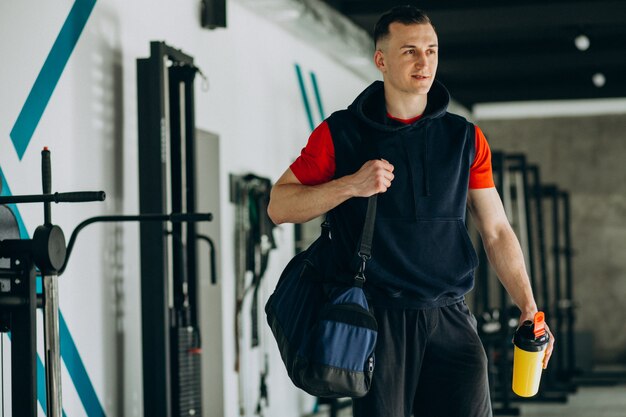 Giovane uomo bello in abiti sportivi in palestra