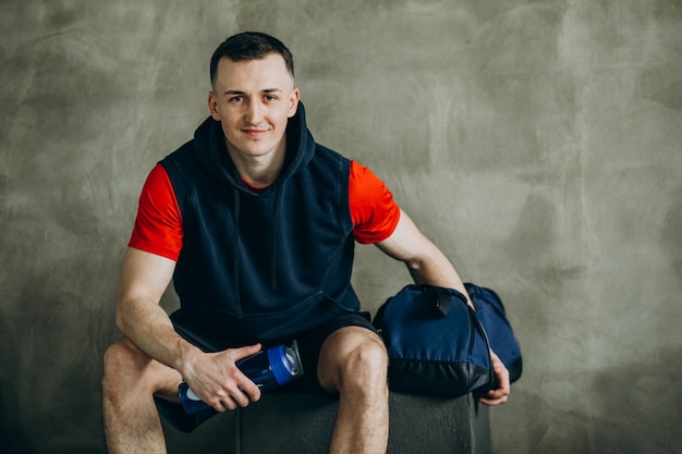 Giovane uomo bello in abiti sportivi in palestra