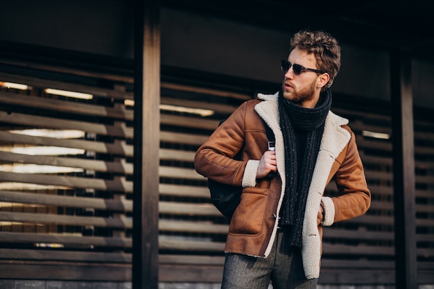 Giovane uomo bello in un vestito di strada