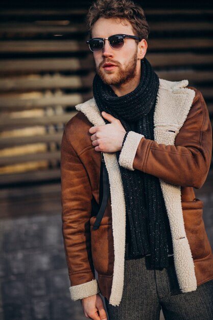 Giovane uomo bello in un vestito di strada