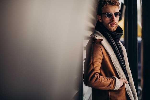 Giovane uomo bello in un vestito di strada