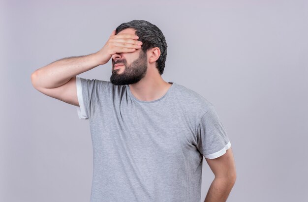 Giovane uomo caucasico bello chiudendo gli occhi con la mano isolata su priorità bassa bianca con lo spazio della copia