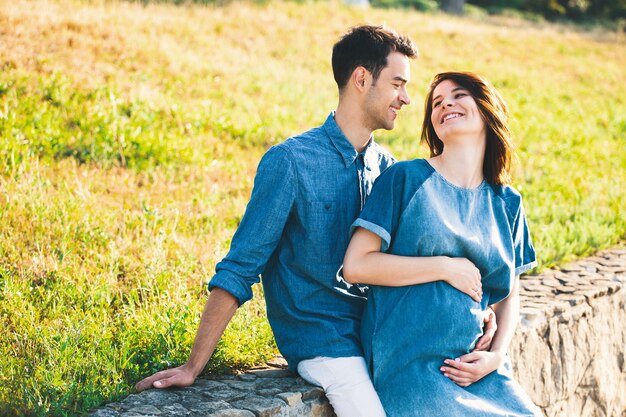 Giovane uomo caucasico che abbraccia moglie incinta