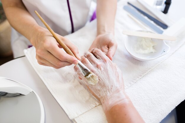 Giovane uomo che fa manicure in salone. Concetto di bellezza.