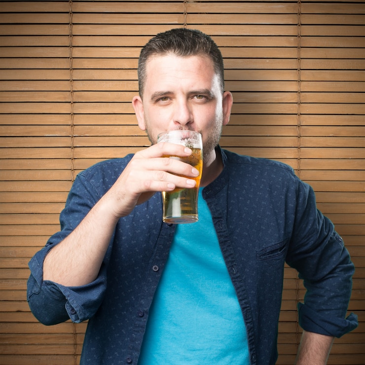 Foto gratuito giovane uomo che indossa un vestito blu. bevendo birra.
