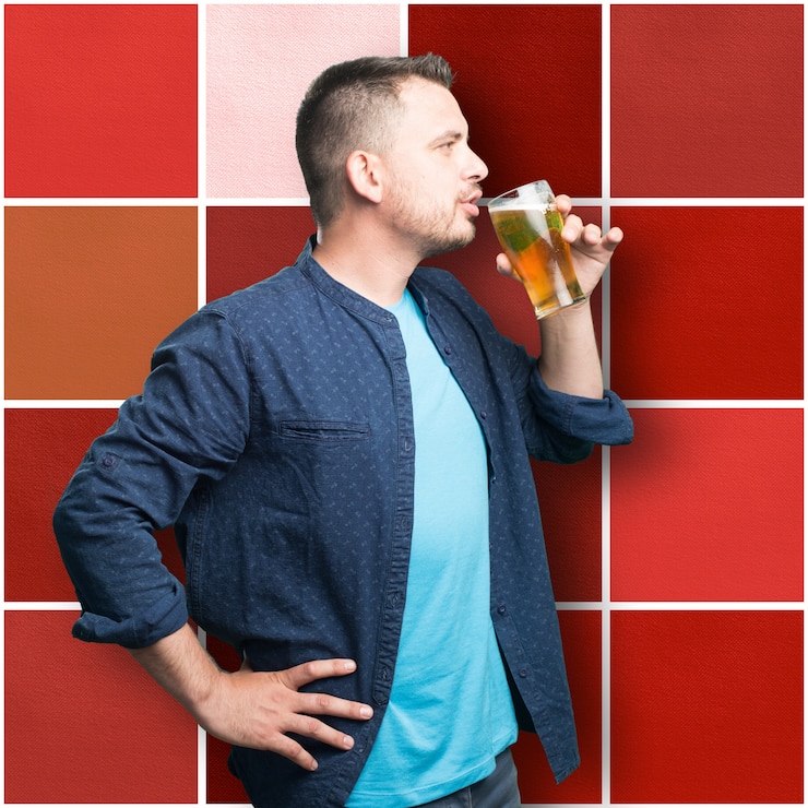 Foto gratuito giovane uomo che indossa un vestito blu. bevendo birra.