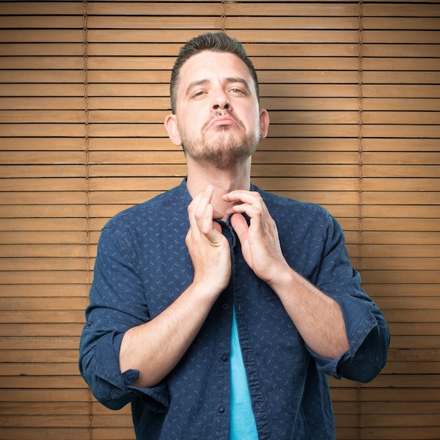 Giovane uomo che indossa un vestito blu. Mettere in ordine la camicia.