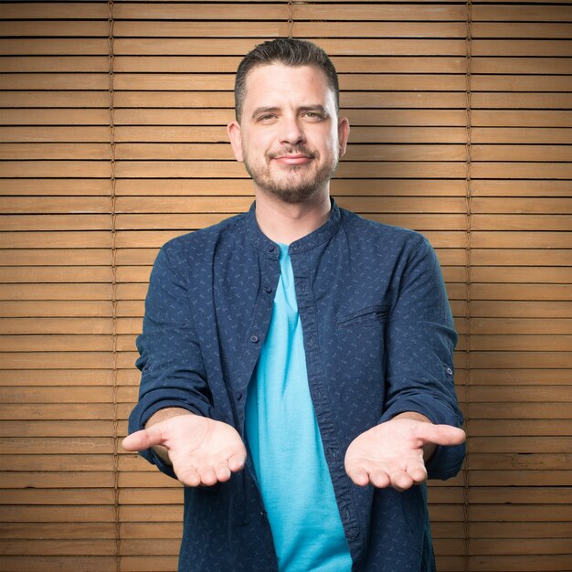 Giovane uomo che indossa un vestito blu. Tenendo gesto.