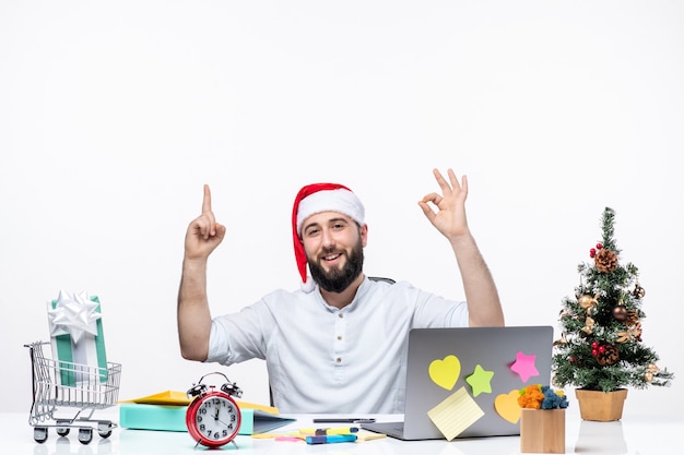 Giovane uomo d'affari in ufficio che celebra puntando verso l'alto facendo un gesto ok