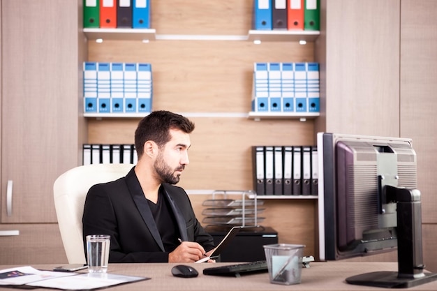 Giovane uomo d'affari stanco che lavora nel suo ufficio. Imprenditore in ambiente professionale