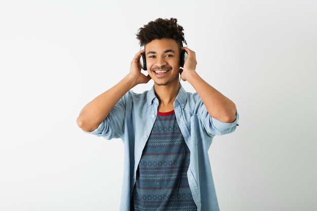 Giovane uomo di colore bello, ascolta la musica in cuffia, espressione del viso sorridente, stato d'animo positivo, emozione felice, isolato su sfondo bianco, gioventù afroamericana, stile hipster, studente