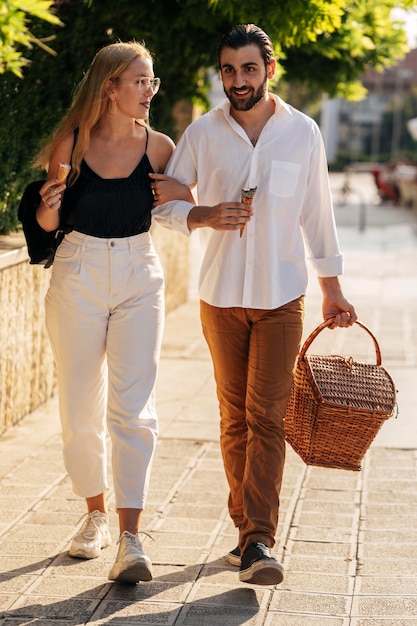 Giovane uomo e donna che vanno al parco per fare un picnic