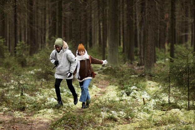 Giovane uomo e donna in una foresta insieme durante un viaggio invernale