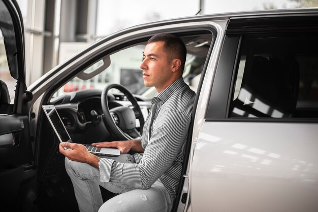 Giovane uomo elegante che prova un'automobile