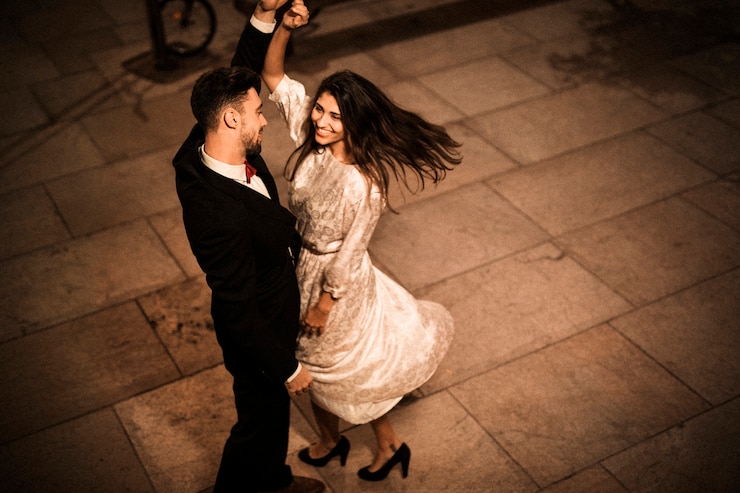 Foto gratuito giovane uomo elegante che tiene la mano di vorticosa donna allegra attraente