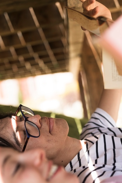 Giovane uomo etnico con il libro di lettura compagno di classe