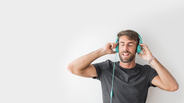 Giovane uomo godendo la musica con gli auricolari