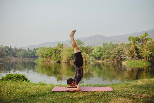 Giovane uomo handstanding con bel paesaggio