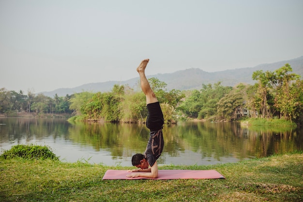 Giovane uomo handstanding con bel paesaggio