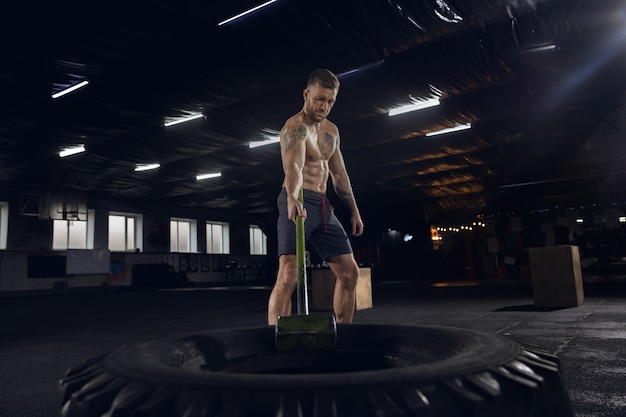 Giovane uomo in buona salute, atleta che fa esercizi di equilibrio in palestra