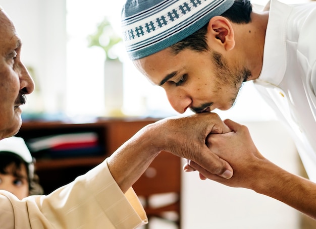 Giovane uomo musulmano che mostra rispetto a suo padre
