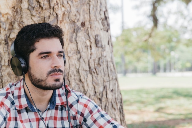 Giovane uomo pensoso ascoltando musica