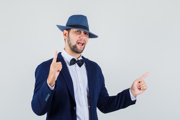 Giovane uomo rivolto verso l'alto e di lato in tuta, cappello e guardando fiducioso, vista frontale.