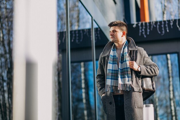 Giovane viaggiatore bello dell'uomo che per mezzo del telefono fuori