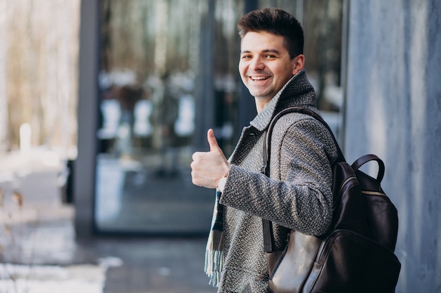 Giovane viaggiatore bello dell'uomo che per mezzo del telefono fuori