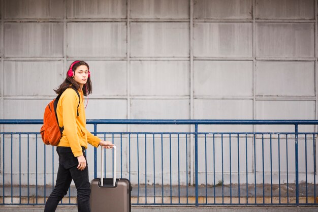 Giovane viaggiatore elegante con bagagli