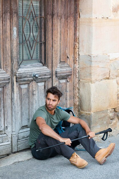 Giovane viaggiatore maschio in alava che tiene un bastone da trekking