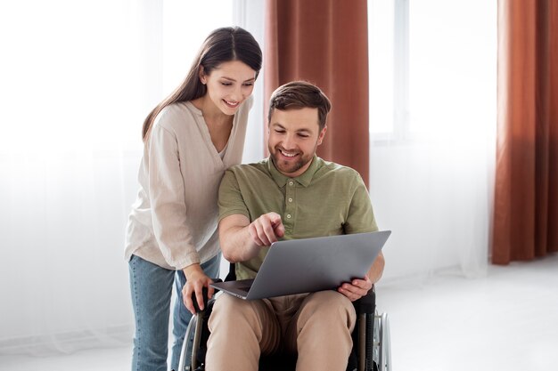 Giovani adulti che guardano programmi TV con un amico disabile