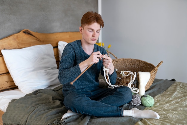 Giovani adulti che lavorano a maglia a casa