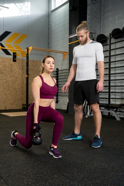 Giovani adulti in palestra sportiva con kettlebell