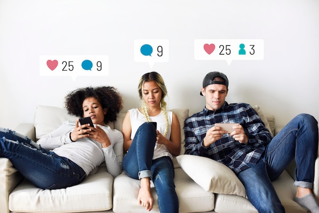 Giovani adulti sul divano che utilizzano i social media sui loro smartphone