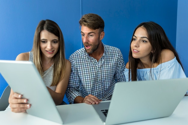 Giovani amici che lavorano con i dispositivi