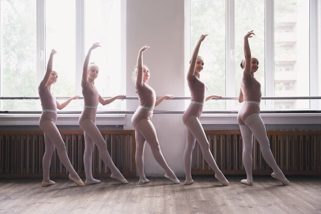 Giovani ballerini di balletto femminili graziosi che ballano alla formazione. Bellezza del balletto classico.