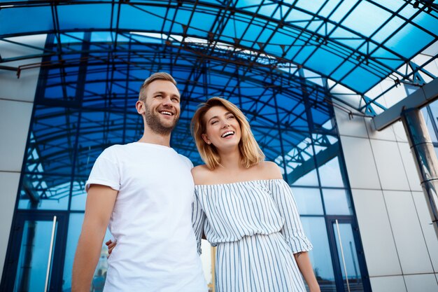 Giovani belle coppie che sorridono, abbracciando, camminando intorno alla città