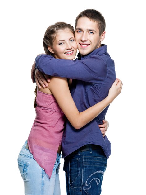 Giovani belle coppie sorridenti felici - muro bianco. Abbracci forti