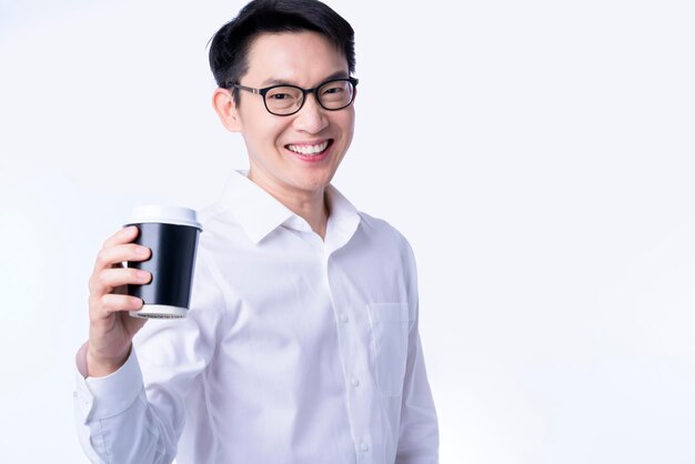 Giovani bicchieri attraenti asiatico maschio mano presente bevanda calda tazza di caffè a te sorriso amichevole e fiducioso uomo d'affari caldo benvenuto alla nuova venuta con caffè espresso caldo bevanda sfondo bianco