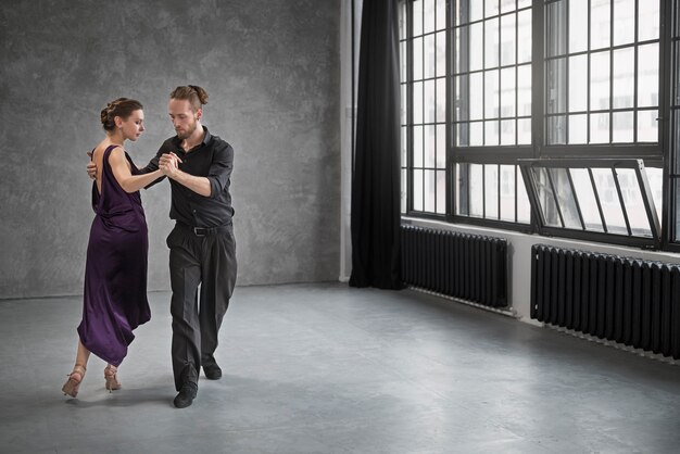 Giovani che ballano il tango in uno studio