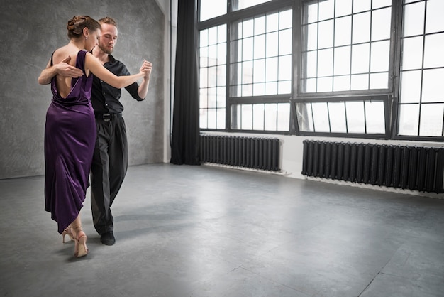 Giovani che ballano il tango in uno studio